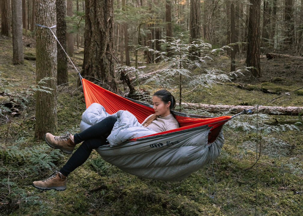 Woman outside using UnderQuilt and TopQuilt to stay warm.