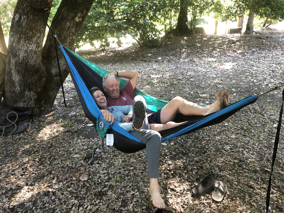 A man and a woman share a PCT Giving back hammock. 